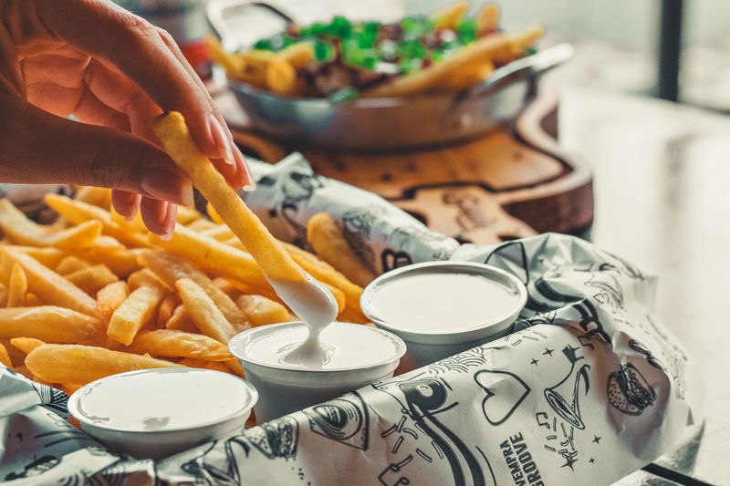 Loaded seasoned fries with seasoning and dipping sauce
